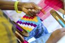A person weaving Kente cloth