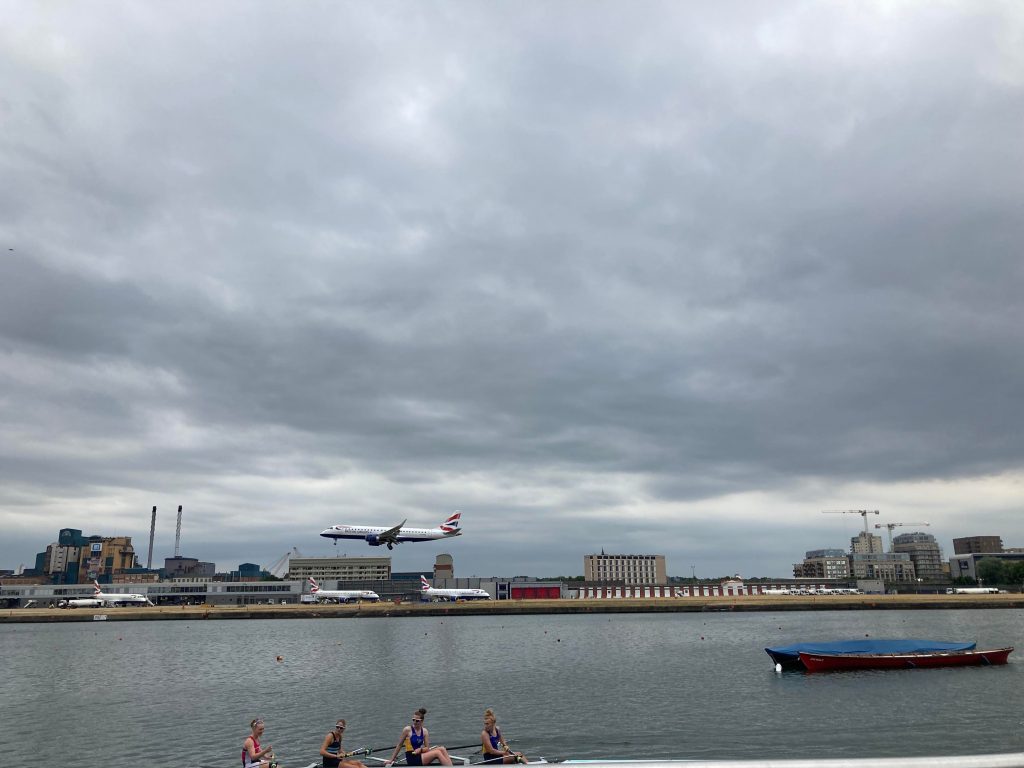 Plane landing at London City Airport across the water from Royal Albert Dock in Newham.