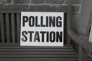 a polling station sign on a bench