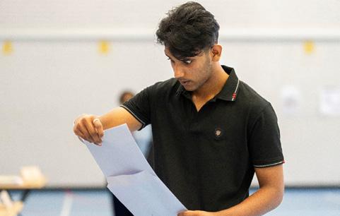 A young man, eyes wide in shock, opens exam results