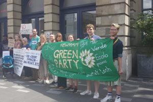 Green Party supporters hold a banner in the street