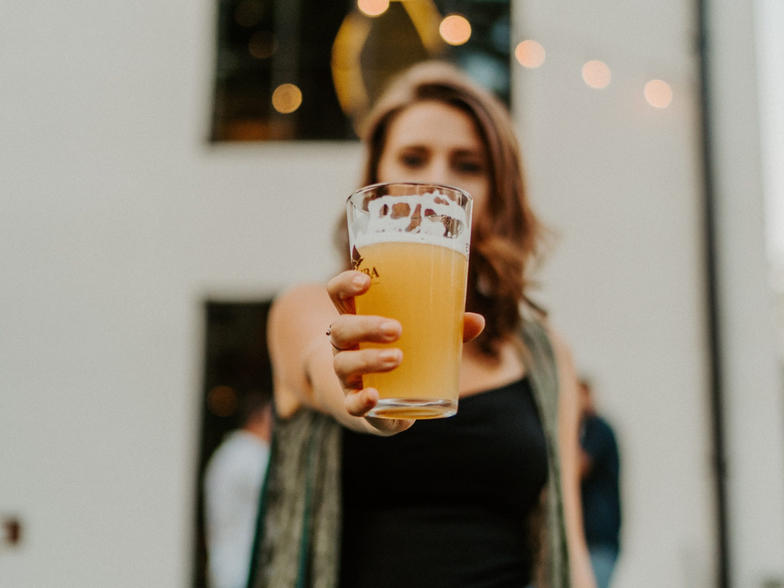 A person holds a pint of beer