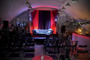 A glamorous drinking space with bunting, tables and glitter curtains