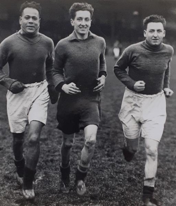 Three footballers train in a black and white photo