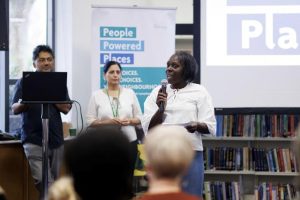 A person with a microphone speaks to a room