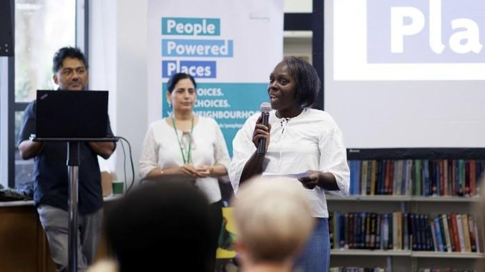 A person with a microphone speaks to a room