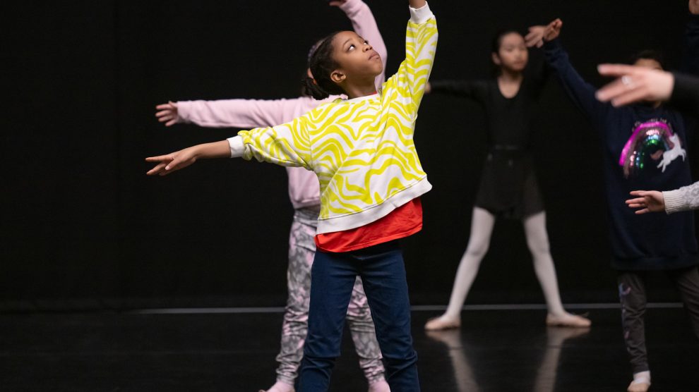 Children practice ballet in a studio