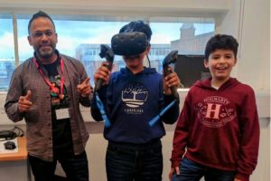 An adult and two young people trying out VR equipment