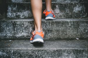 a pair of feet in trainers run up some stone steps