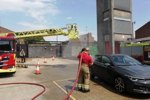 Firefighters at a firestation wash a car