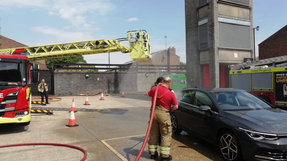 Firefighters at a firestation wash a car