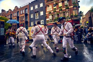A morris side perfom in a city street