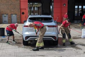 Firefighters wash a car
