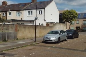 Cars parked at the foot of a parking control sign