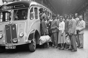 people stand by a bus in a black and white photo