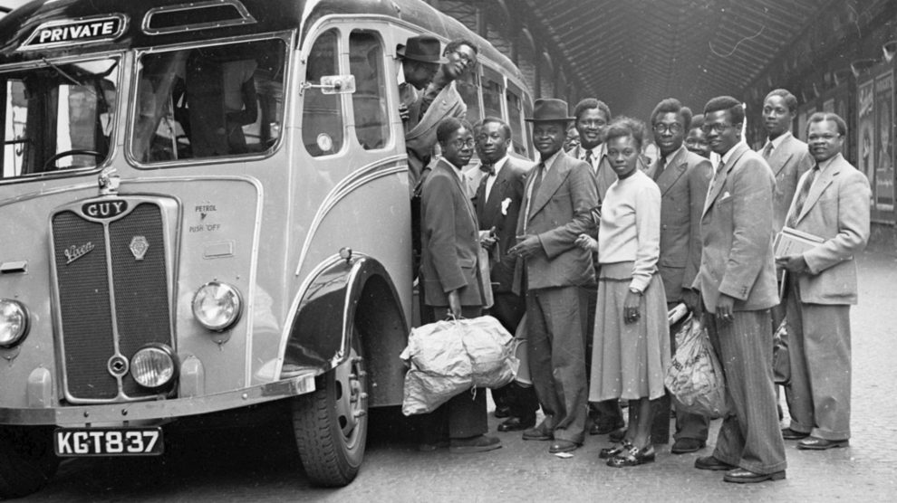people stand by a bus in a black and white photo