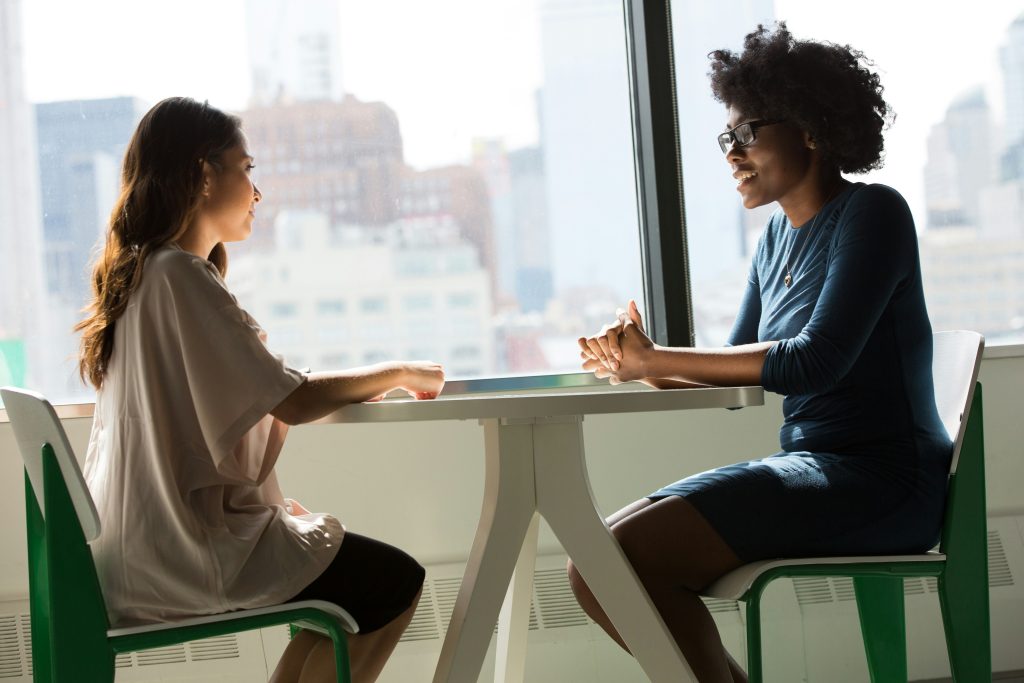 a younger person and an older person face each other across a table