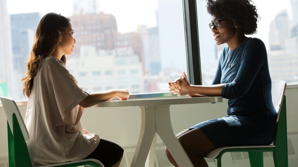 a younger person and an older person face each other across a table