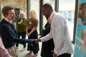 A royal family member shakes the hand of a young man
