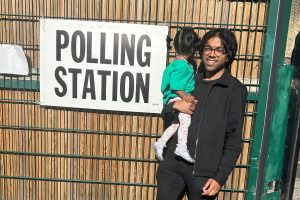 Areeq Chowdhury stands by a polling station sign