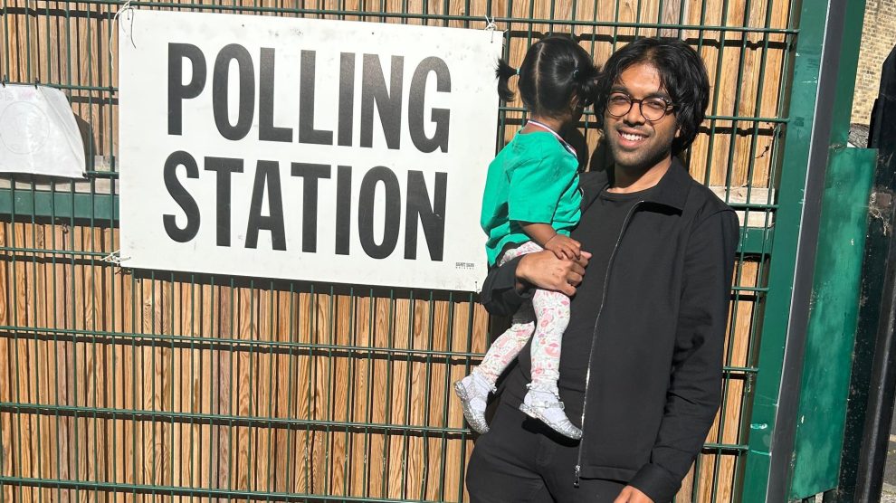 Areeq Chowdhury stands by a polling station sign