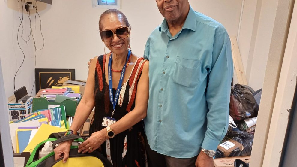 two people pose amonst donated good