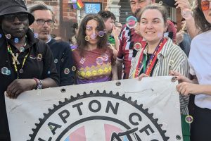 a group of people hold a banner that says 'Clapton FC against Terfs'
