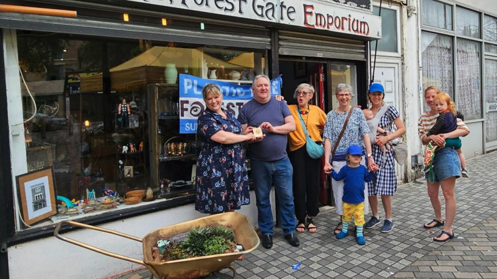 The business owners proudly accept their award in front of their shop