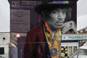 A mural of Jimi Hendrix looks down from a wall