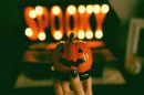 an illuminated sign saying 'spooky' with a small pumpkin in front