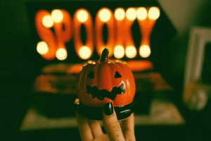 an illuminated sign saying 'spooky' with a small pumpkin in front