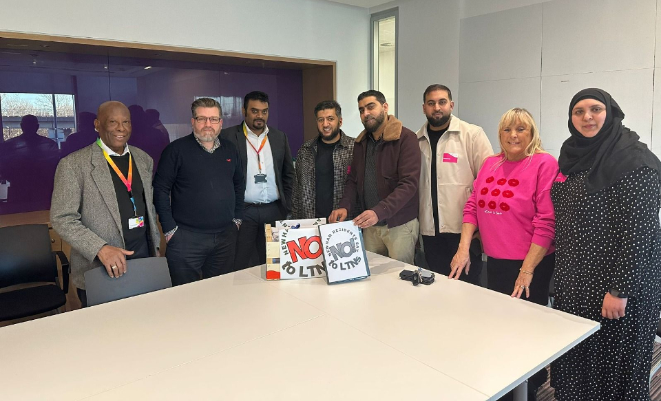 A group of people standing behind a table