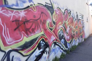A wall covered in brightly coloured graffiti tags.