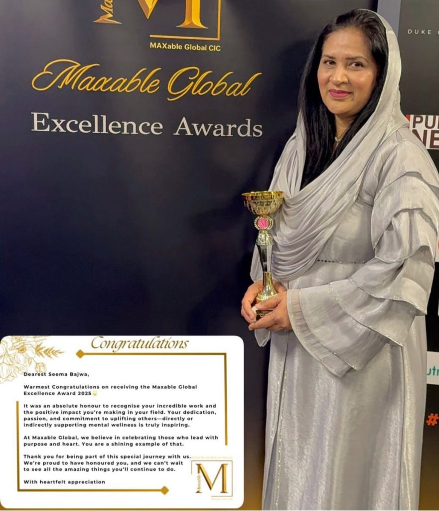 A woman holding a trophy standing in front of an awards sign