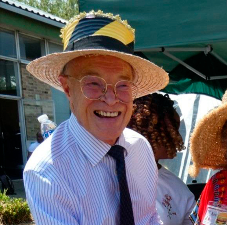 A man in a straw hat wearing a shirt and a tie
