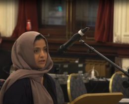 A woman wearing a hijab speaking into a microphone