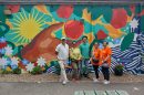 Five people standing in front of a colourful mural