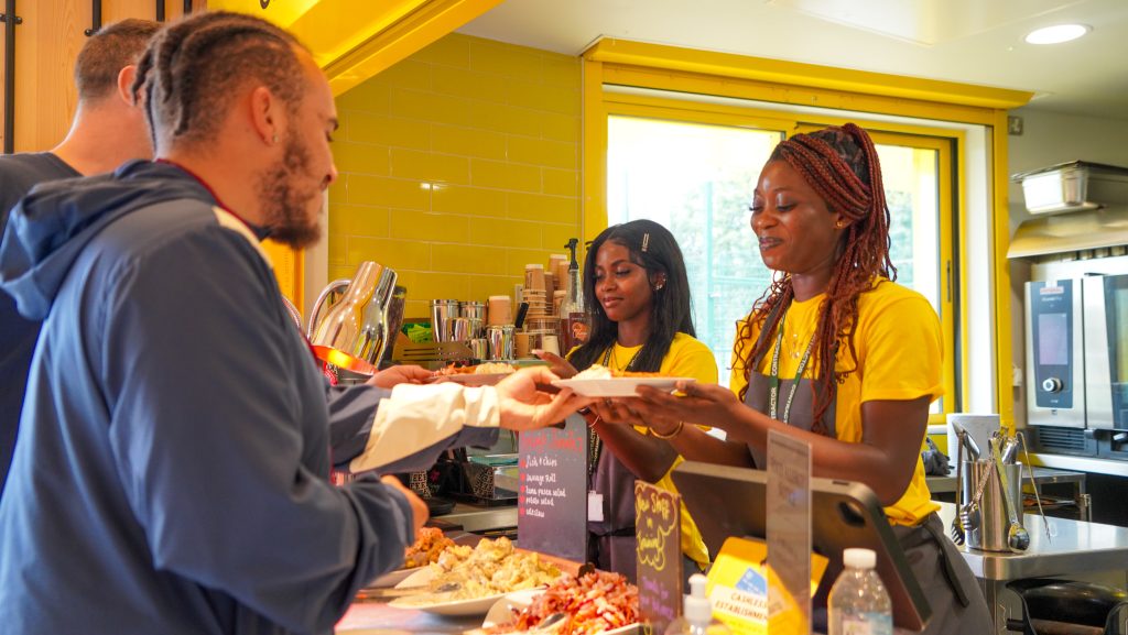 Hungry young footballers being served delicious meals