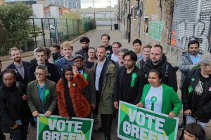 Green Party leader Zack Polanski (centre, brown coat) and to his left Newham mayoral candidate Areeq Choudhury in Stratford (credit Nick Clark/LDRS)