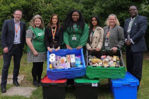 A group of people pose with collected food bank donations