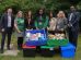A group of people pose with collected food bank donations